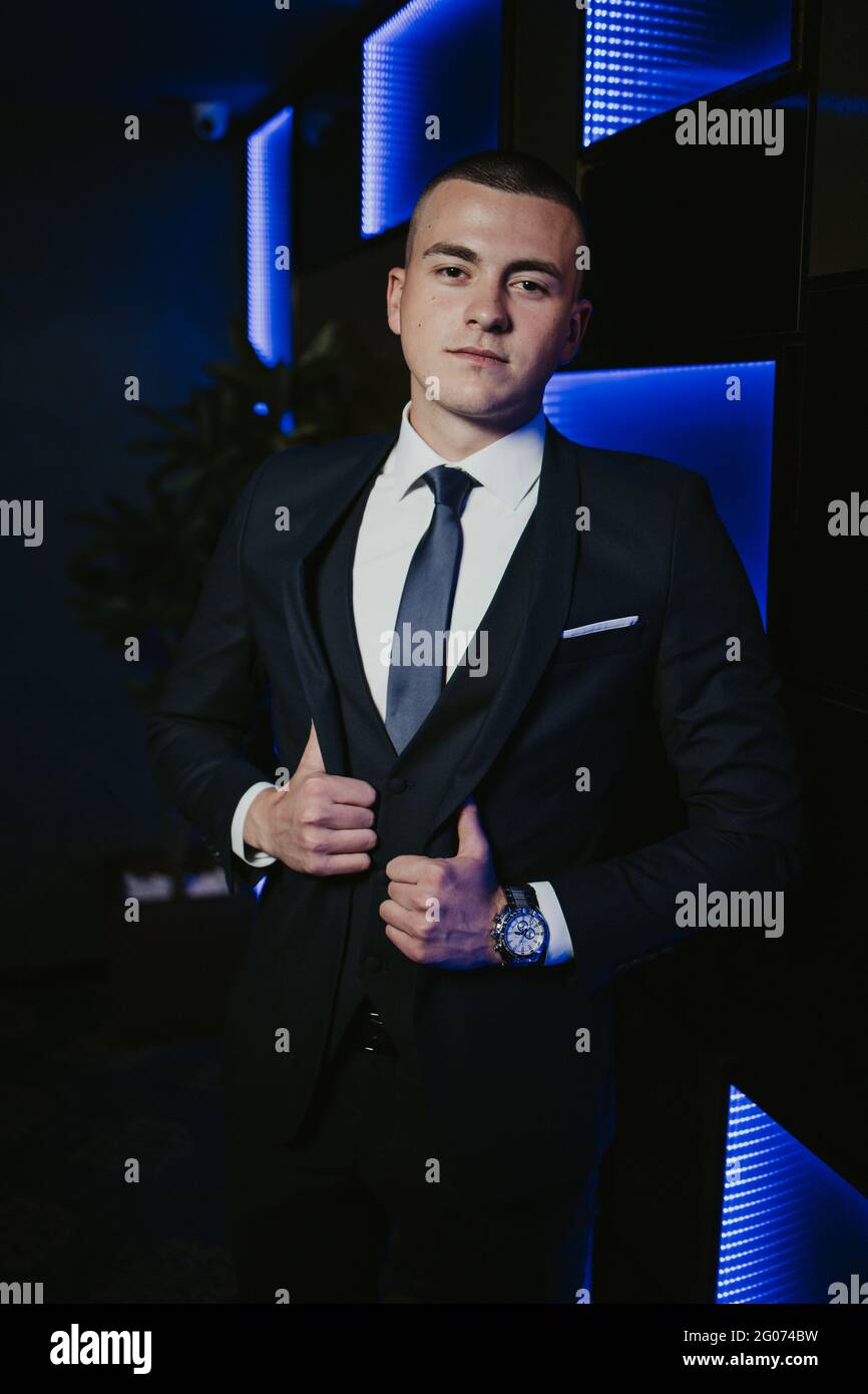 Young man in an elegant black suit with a tie and a watch posing Stock ...
