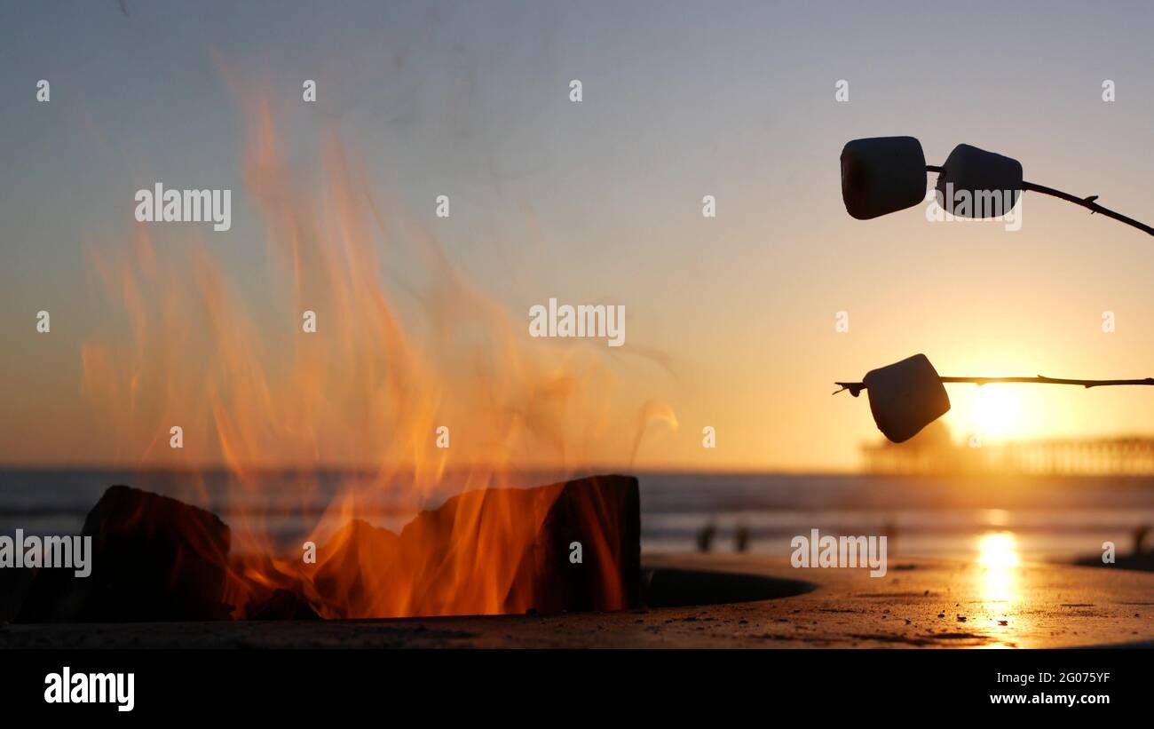 Campfire pit by Oceanside pier, California USA. Camp fire on ocean beach, bonfire flame in