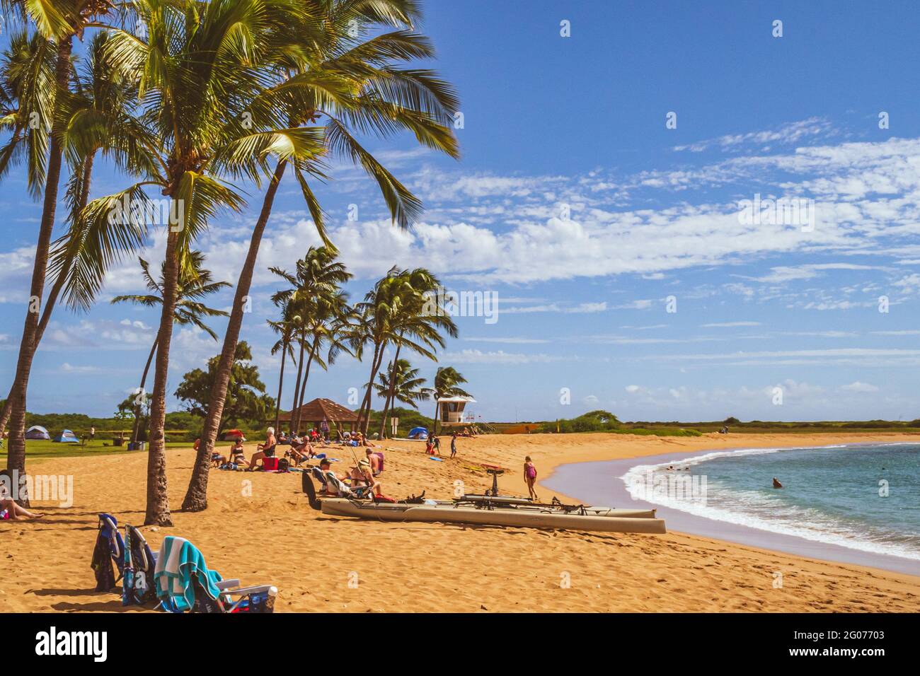 People enjoy tropical paradise beach views in Hawaii on sunny day Stock Photo