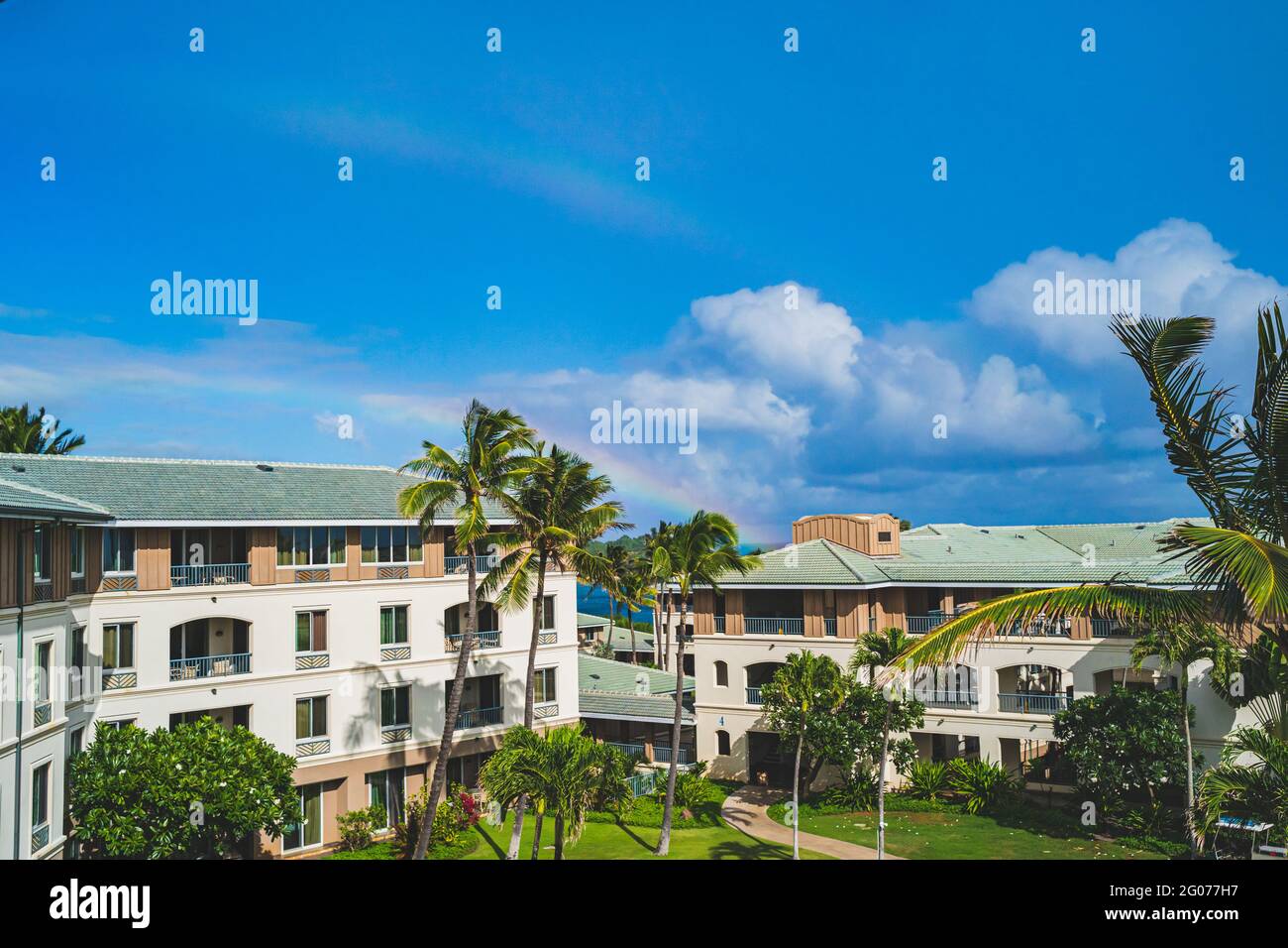 Double rainbow in blue sky above resort grounds in tropical paradise Stock Photo