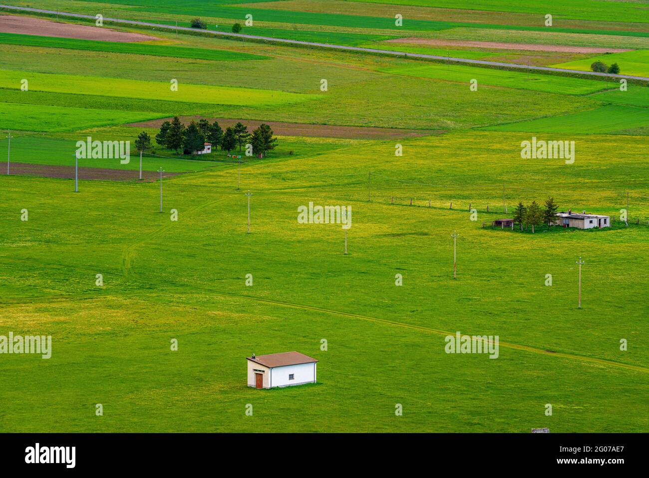 top view of farms amidst green meadows in the mountains. Abruzzo, Italy, EUropa Stock Photo