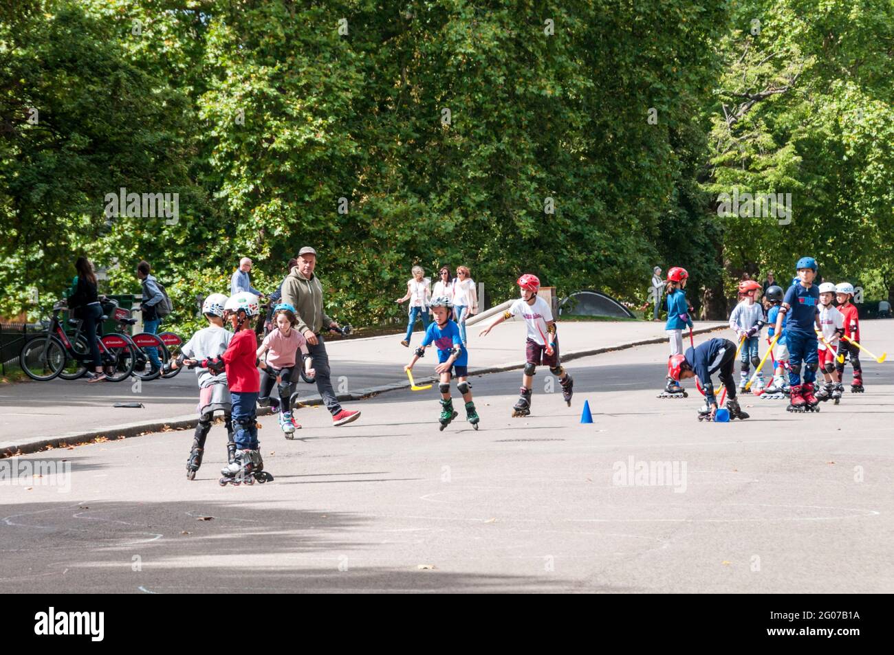 Children playing rollerblade hockey in Kensington Gardens, London. Stock Photo