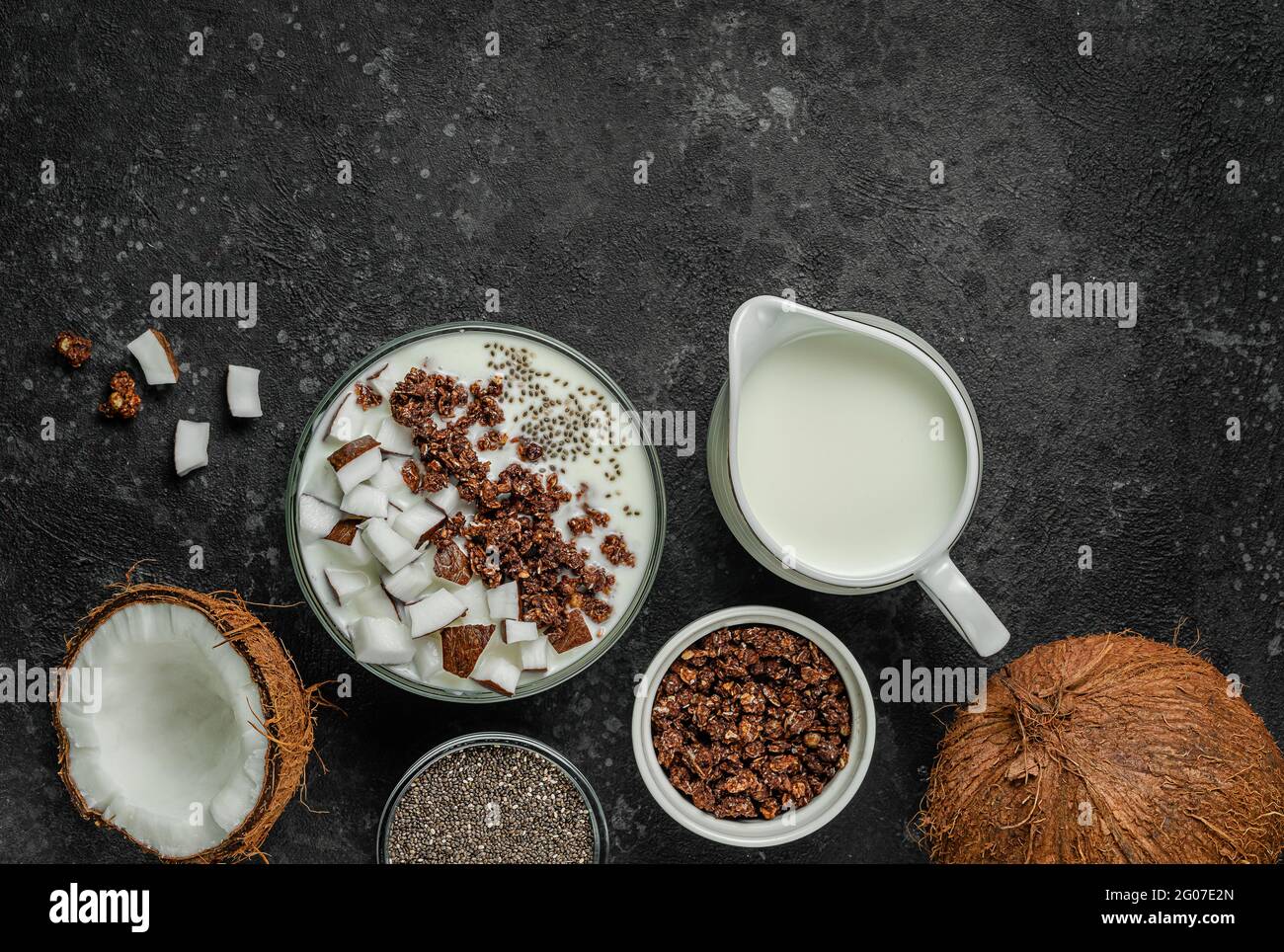Granola bowl with coconut milk and chia seeds on dark background. Top view, copy space. Stock Photo