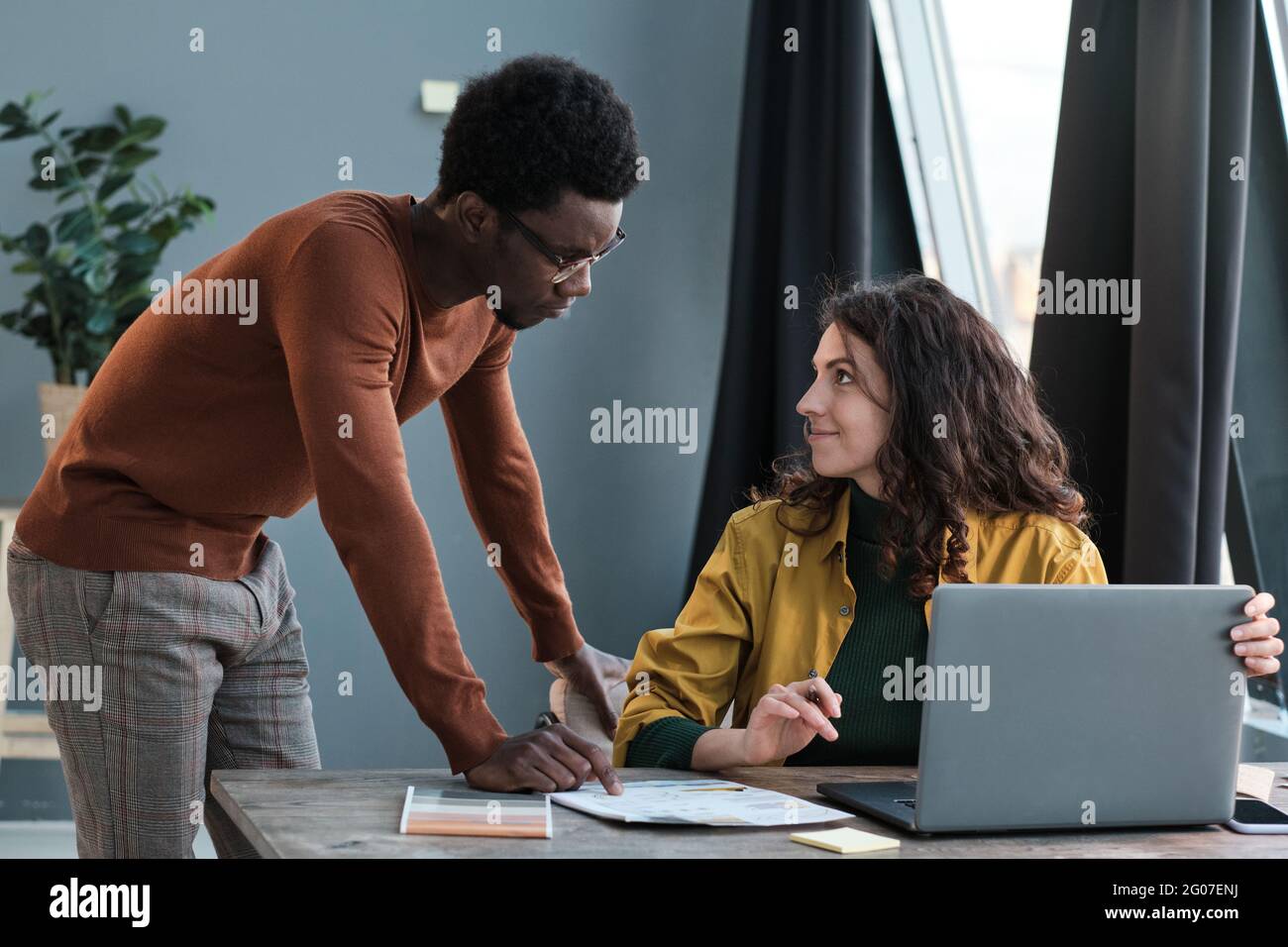 Two business colleagues discussing together and using laptop at work Stock Photo