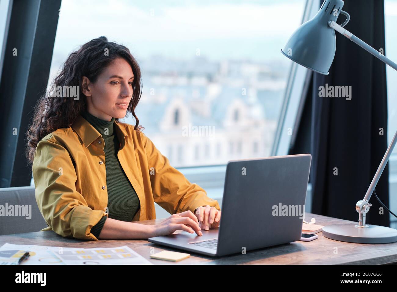 Young office worker typing on laptop computer she working at office Stock Photo