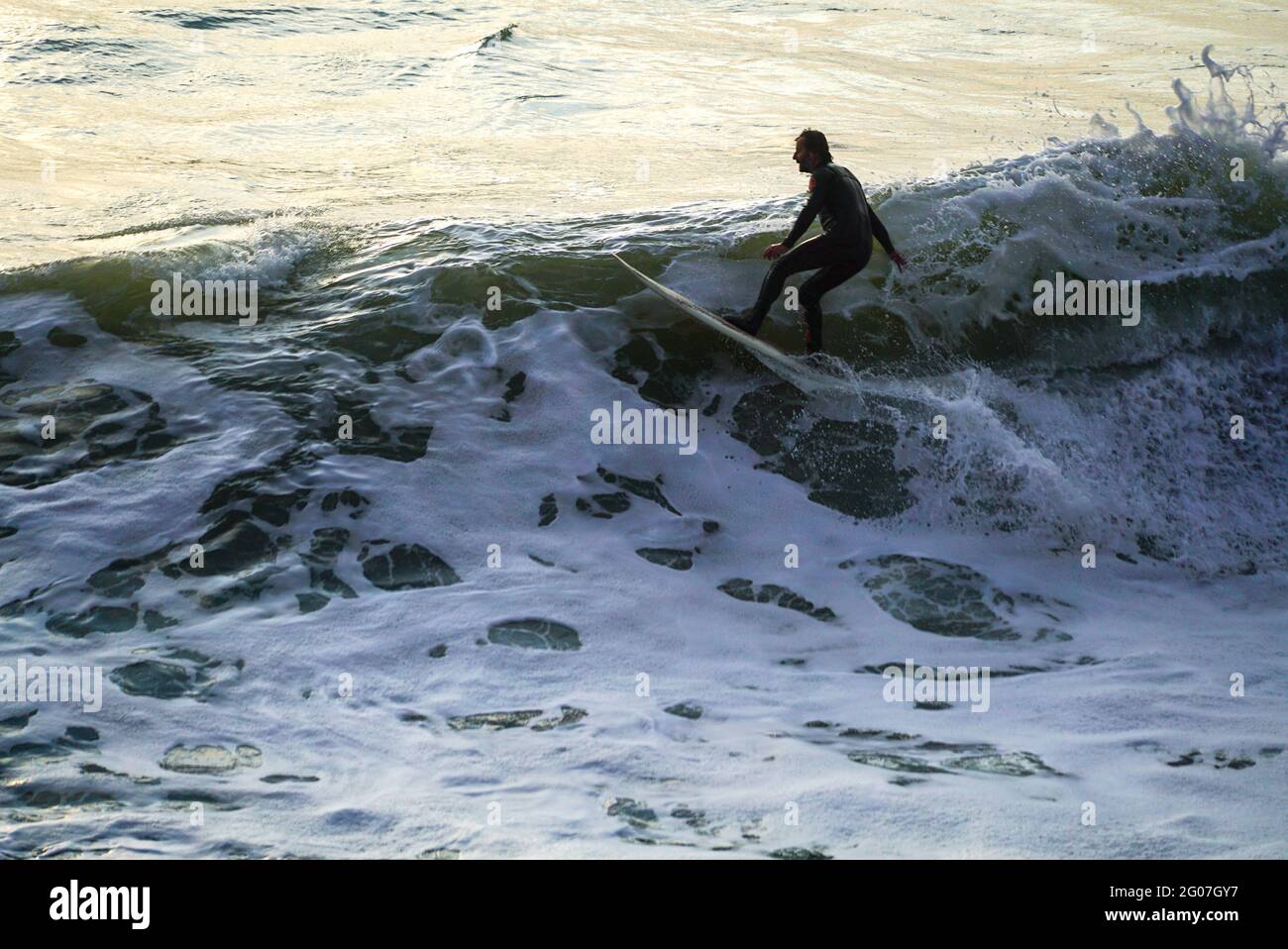 Surfing at Sunset in Beach Dorset UK Stock Photo Alamy