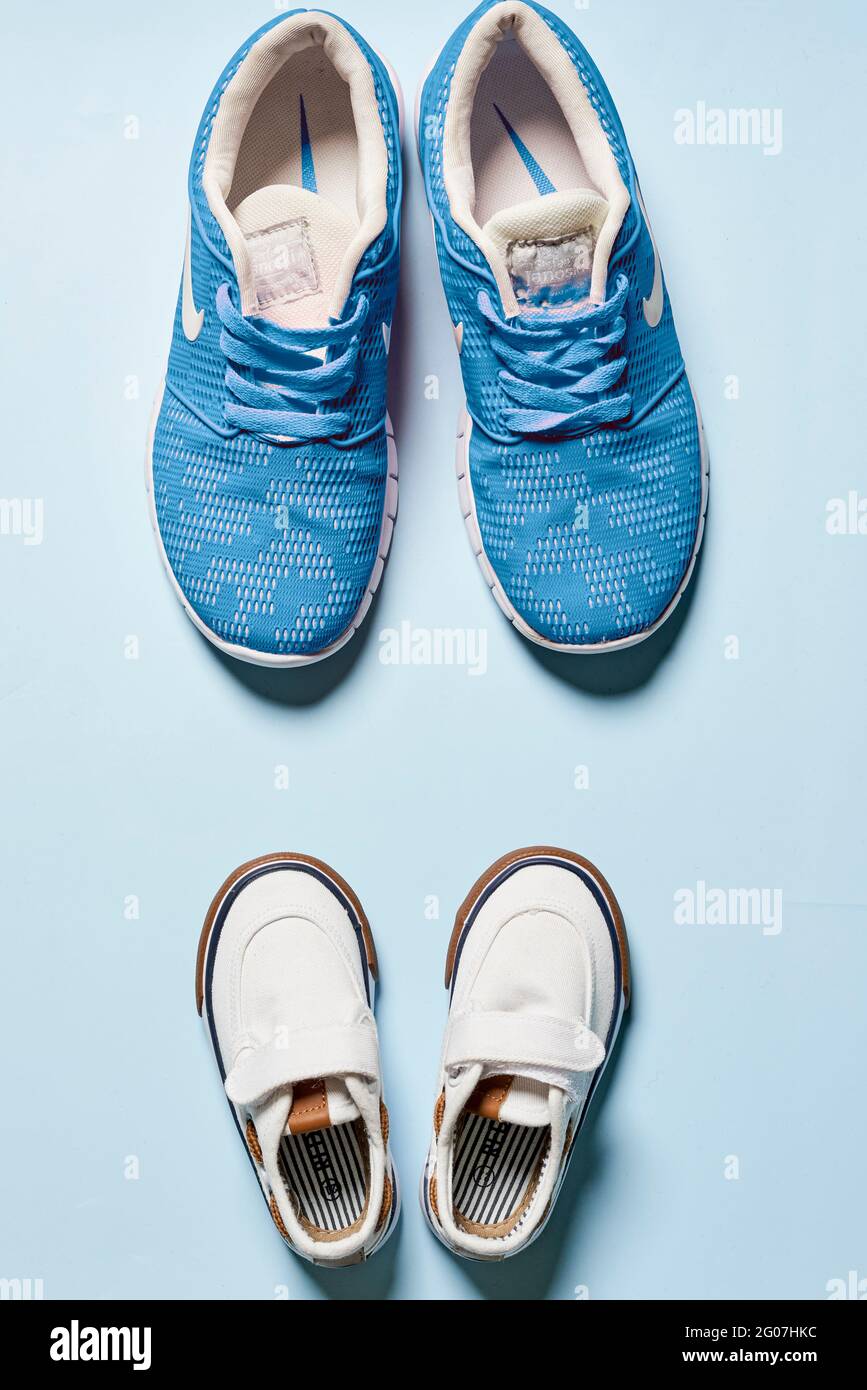 Children's and adult pair of sneakers on isolated background Stock Photo