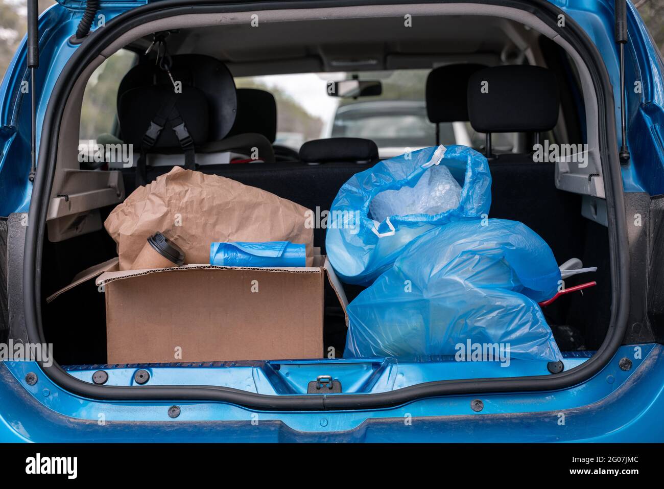 carton box with paper cup near trash bags in modern car Stock Photo Alamy