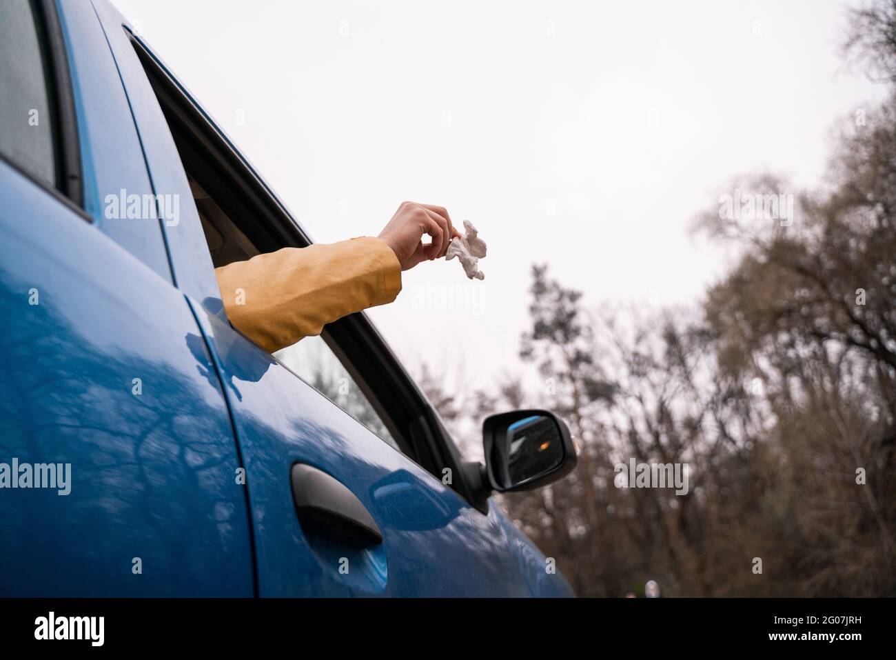 cropped view of man throwing away used napkin from car Stock Photo