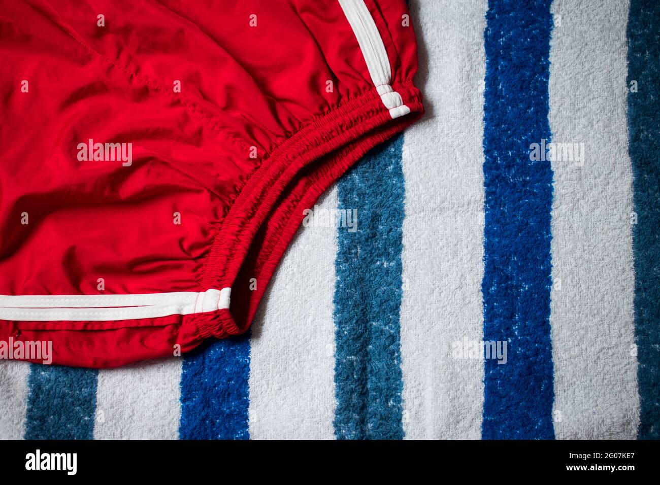 Red short pants on blue and white striped towel for summer Stock Photo