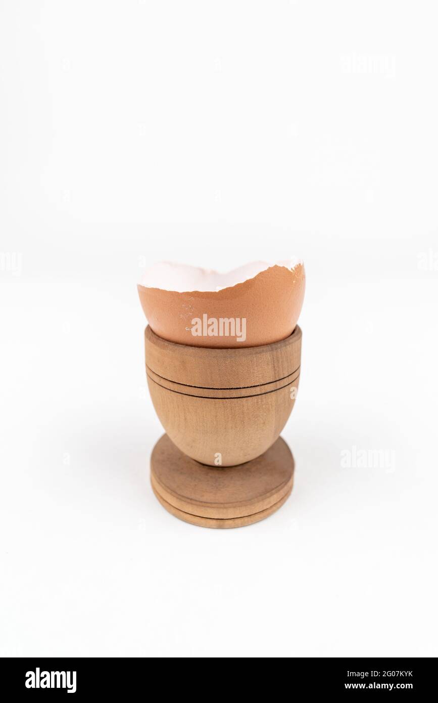 Vertical shot of broken egg shell in old wooden egg stand. Minimalism. Conceptual art for food or animal products. Sustainability issue. Simple breakf Stock Photo