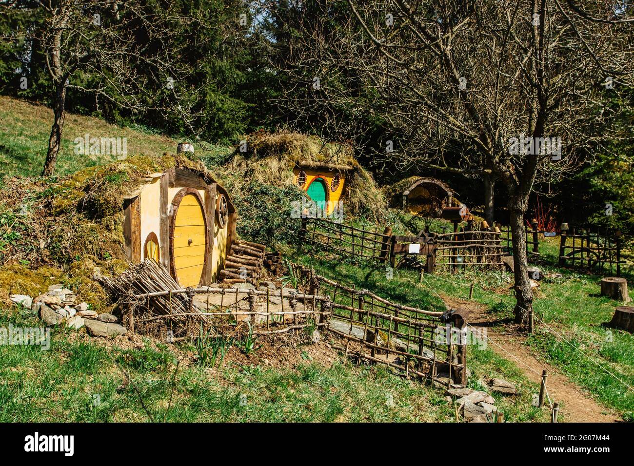 Hobbit house in Czech Hobbiton with three Hobbit holes and cute yellow green doors.Fairy tale home in garden.Magic small village from fantasy movie lo Stock Photo