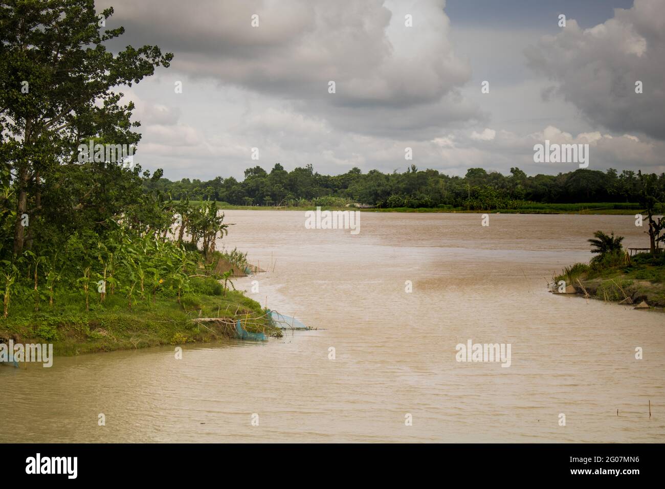 Bangladesh is a riverine country. A beautiful Crooked small river. The small river merges with the big river. Stock Photo