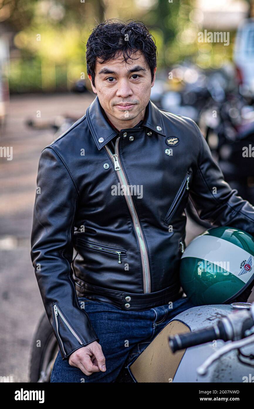 Asian man wearing black leather jacket sitting on motorcycle  display picture 1