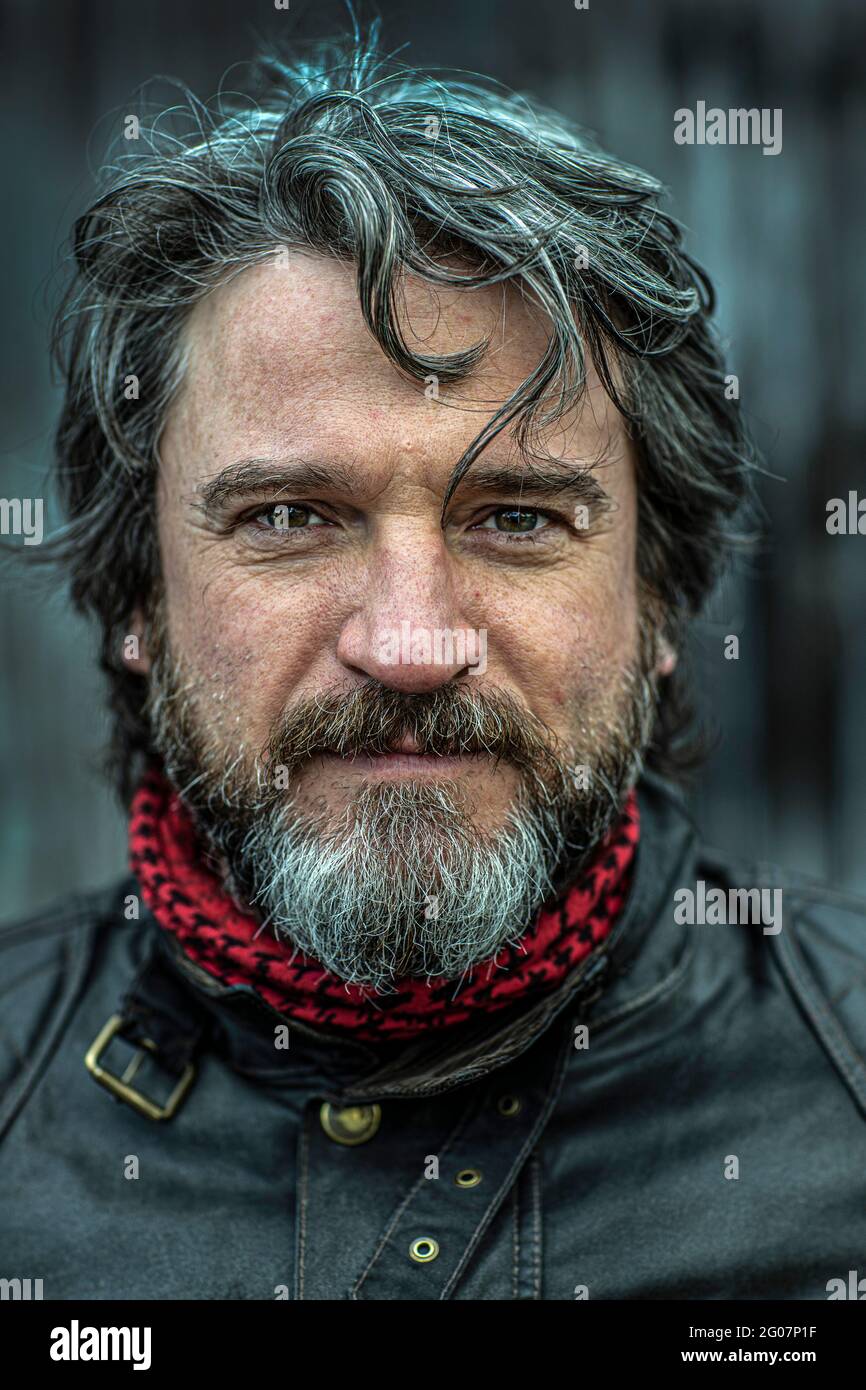 Portrait of middleaged biker with beard and black leather jacket Stock