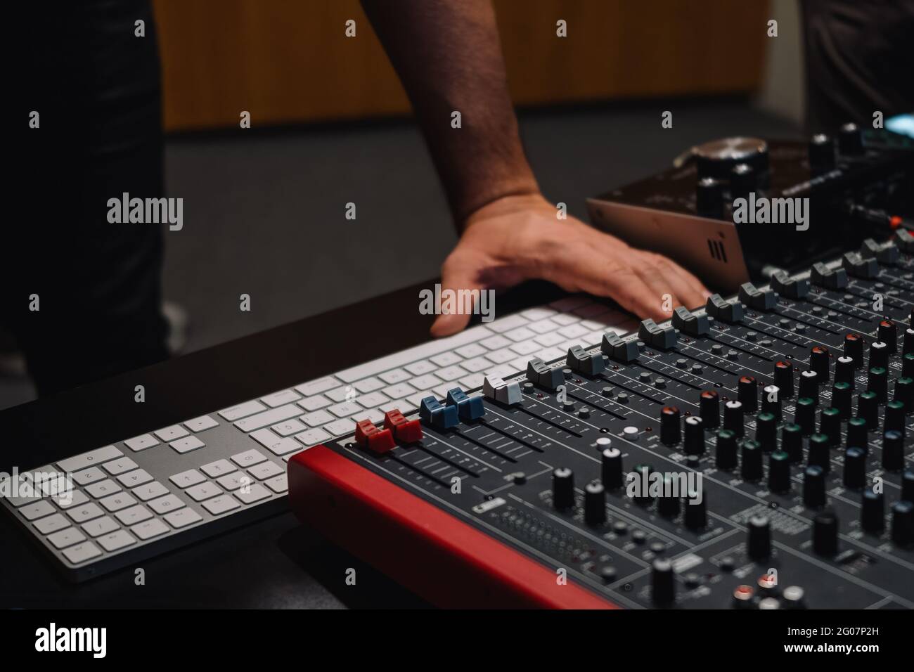 Producer's hands at the keyboard in a studio. Musician arranging and mixing music in home studio. Music production equipment. Stock Photo