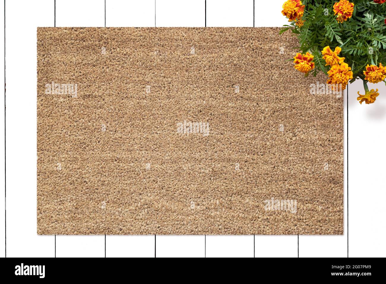 Mockup of Coir Doormat on wooden floor with flowers Stock Photo