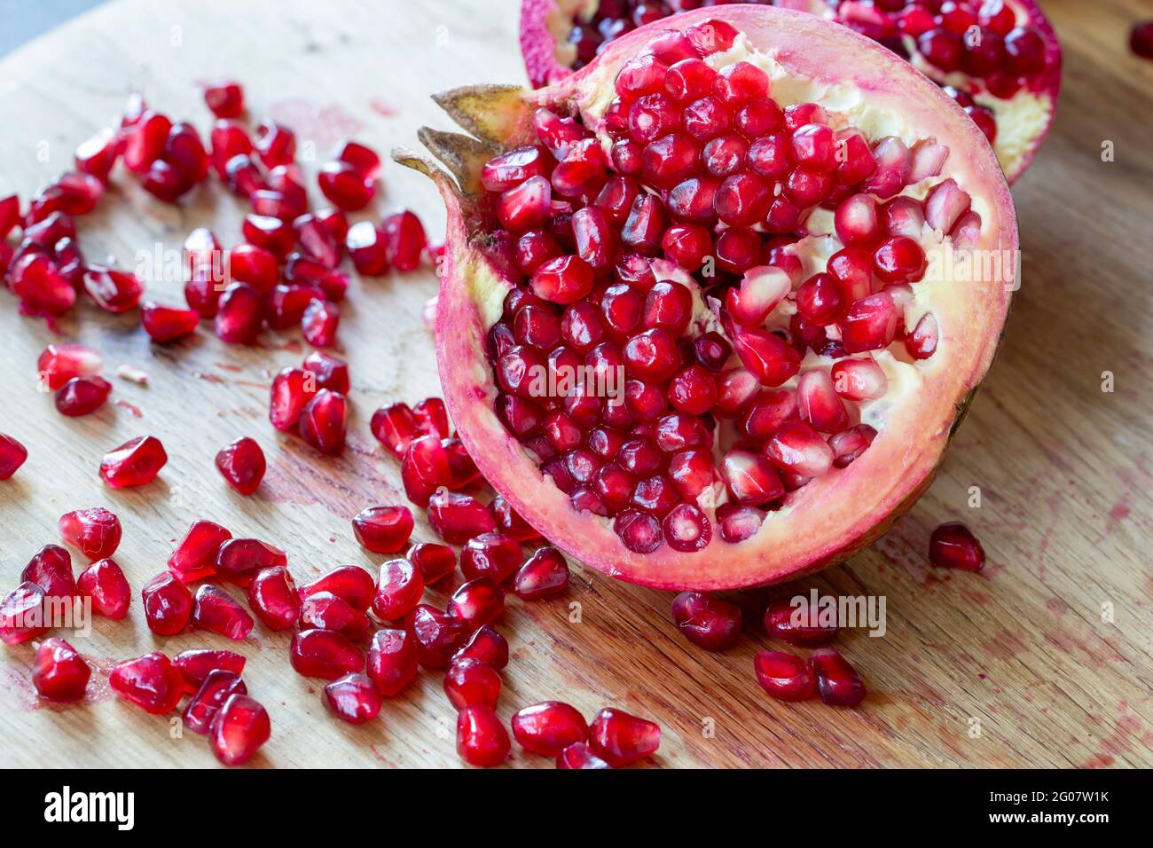 Ripe red pomegranate on wooden board and dark background Stock Photo