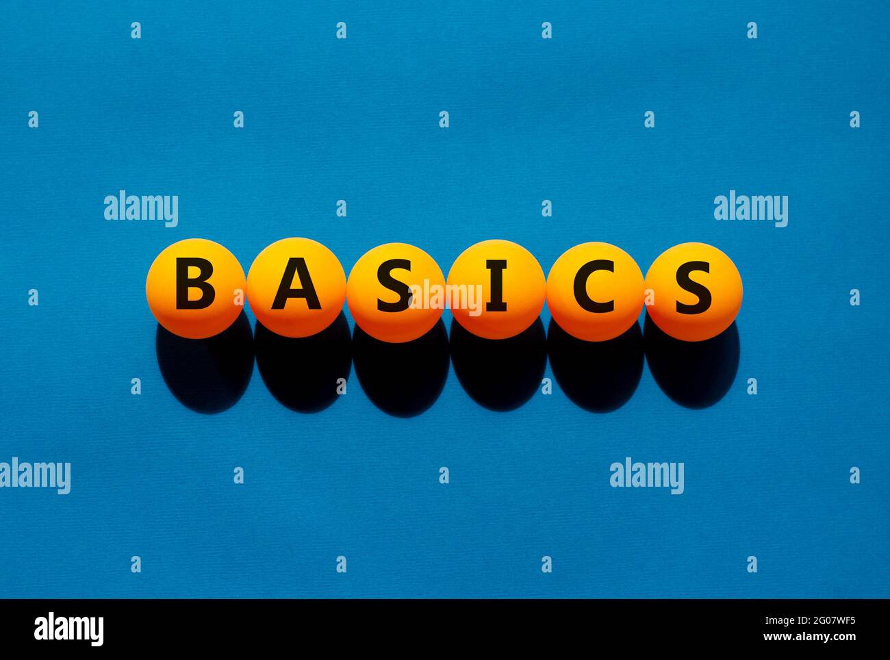 Basics and business symbol. The concept word 'basics' on orange table ...