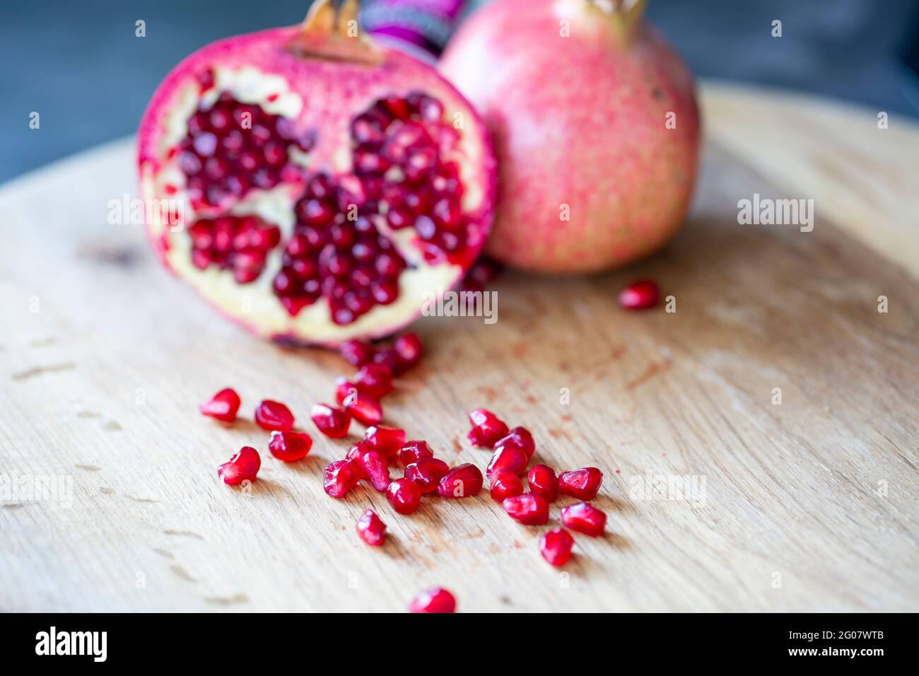 Ripe red pomegranate on wooden board and dark background Stock Photo