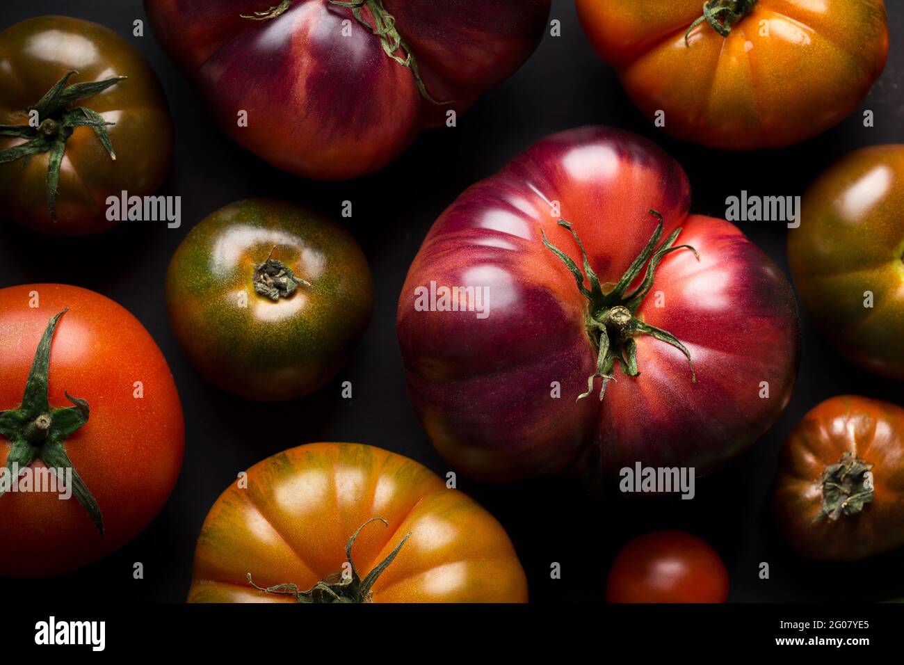 From above different fresh tomatoes on a black table Stock Photo