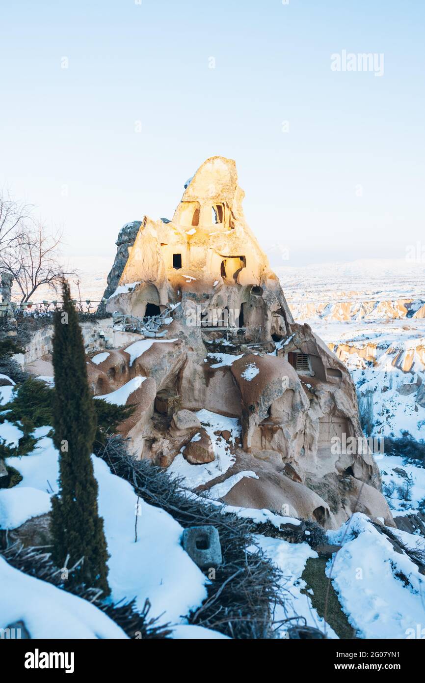 From above of aged castle carved in rock and covered with white snow against cloudless sky on street of Uchisar settlement in Cappadocia, Turkey Stock Photo