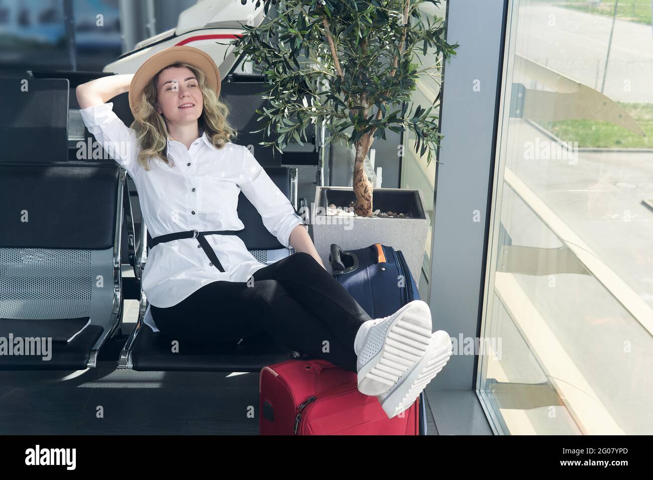 happy woman traveler in airport lounge waiting to board Stock Photo