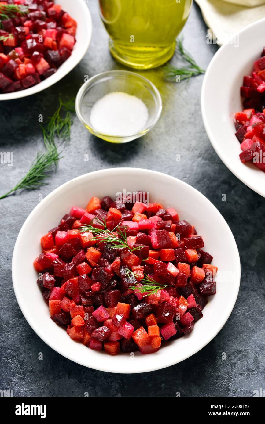 Beet salad in bowl. Healthy detox salad with beetroot, potato, carrot, pickles on blue stone background. Stock Photo