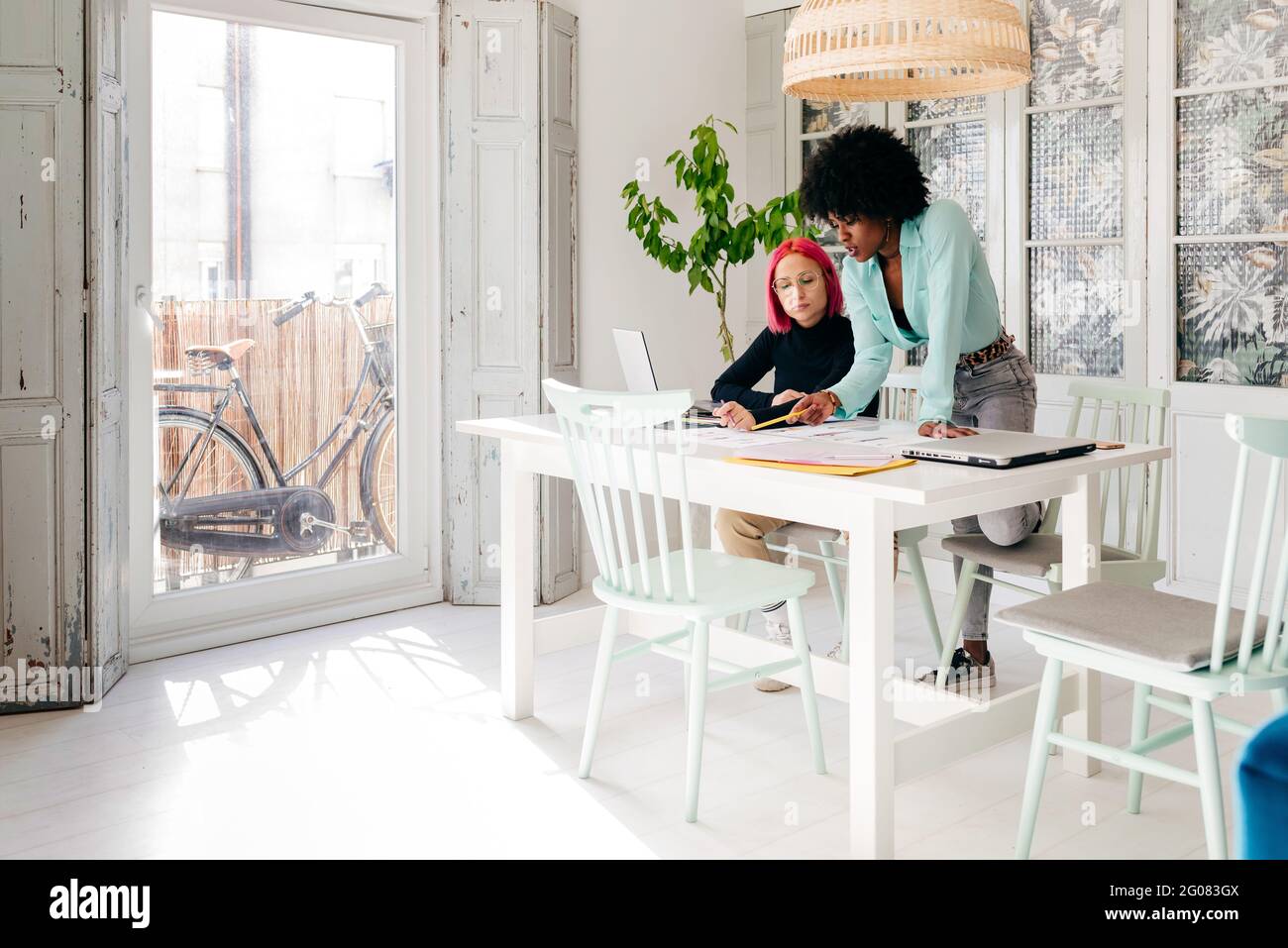 Young multiracial female fashion designers discussing sketches for new ...