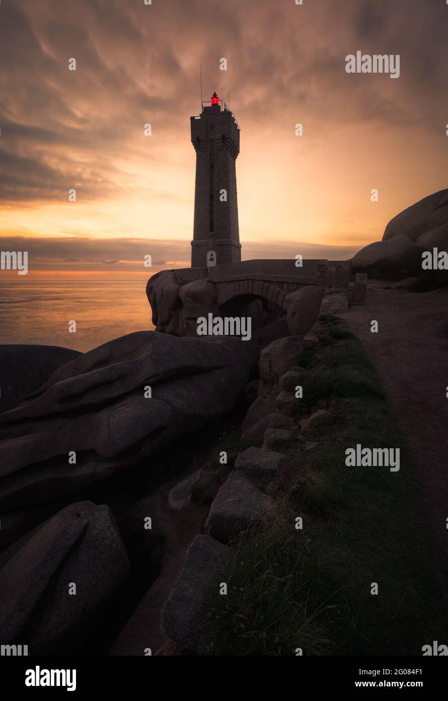 From below lighthouse on the French coast at sunset with a cloudy sky ...