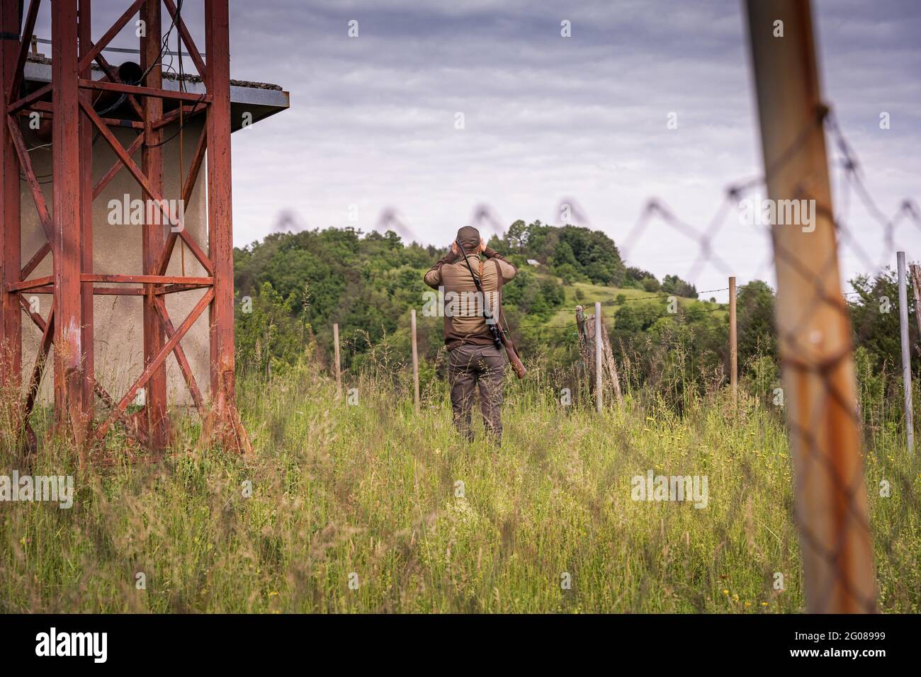 Security guard in post apocalyptic environment using binoculars Stock Photo