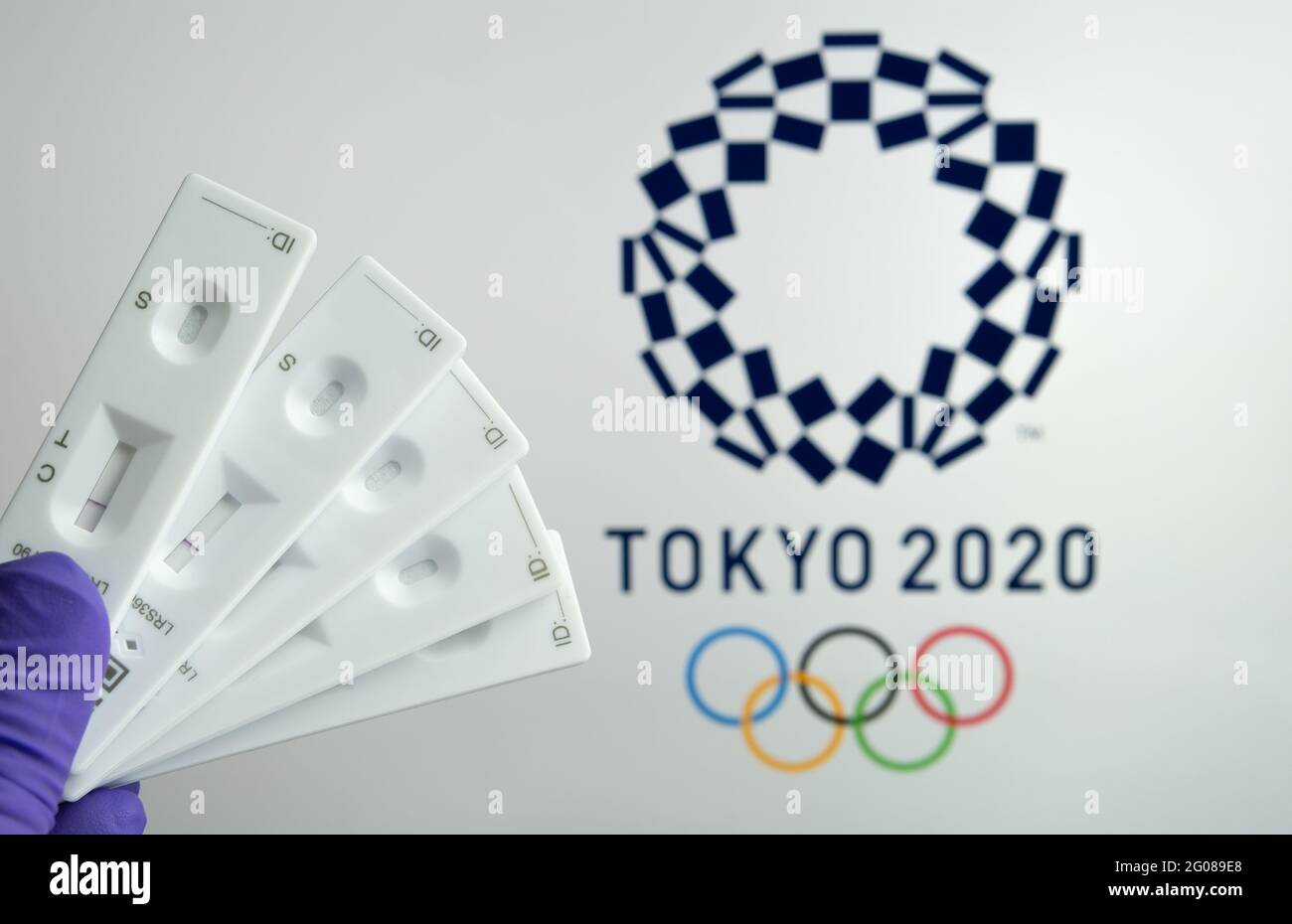 Negative PCR tests in front and blurred Tokyo 2020 logo on the blurred background. Concept for Tokyo COVID Olympic games in 2021. Stafford, United Kin Stock Photo