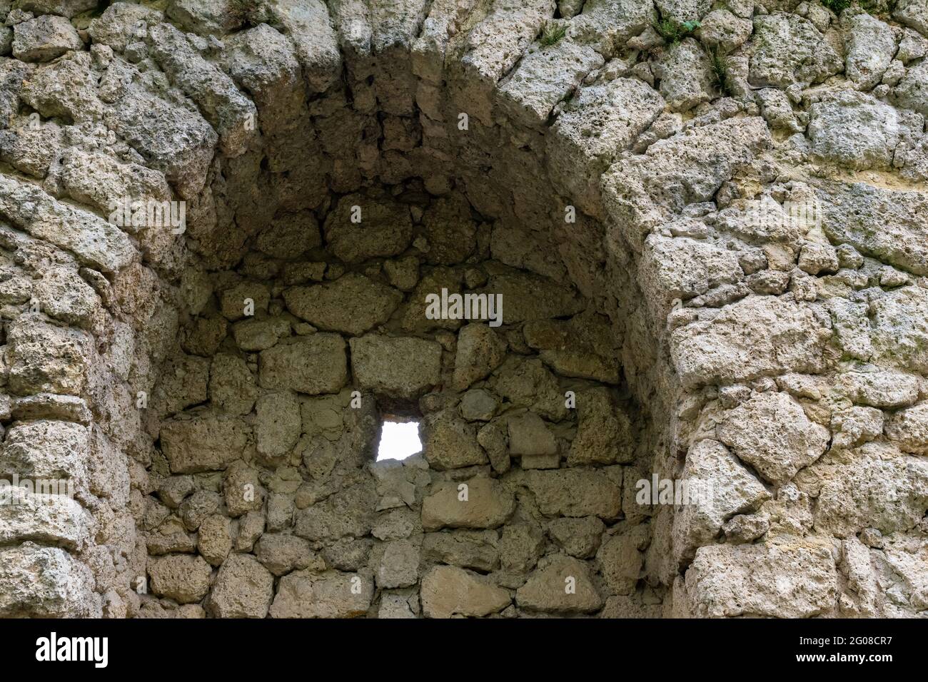 Closeup shot of a medieval stone wall with an arch and a small window ...