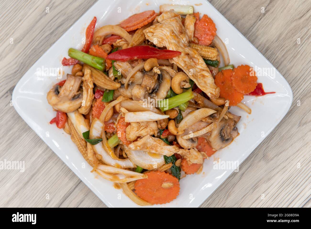 Overhead view of spicy stir fry of cashew nuts, chicken, baby corn, and