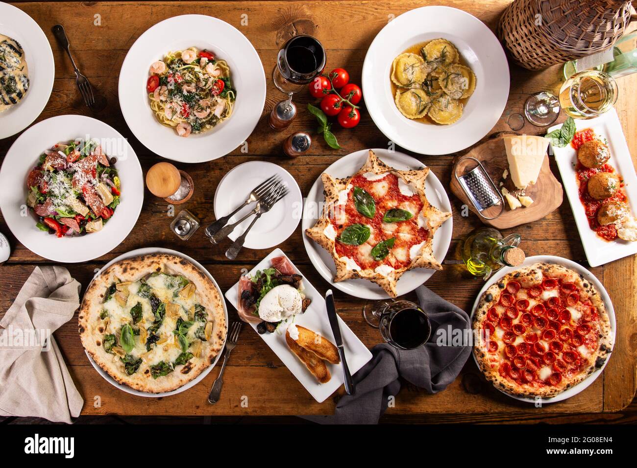 Big dinner table with italian food, pizzas and pastas Stock Photo
