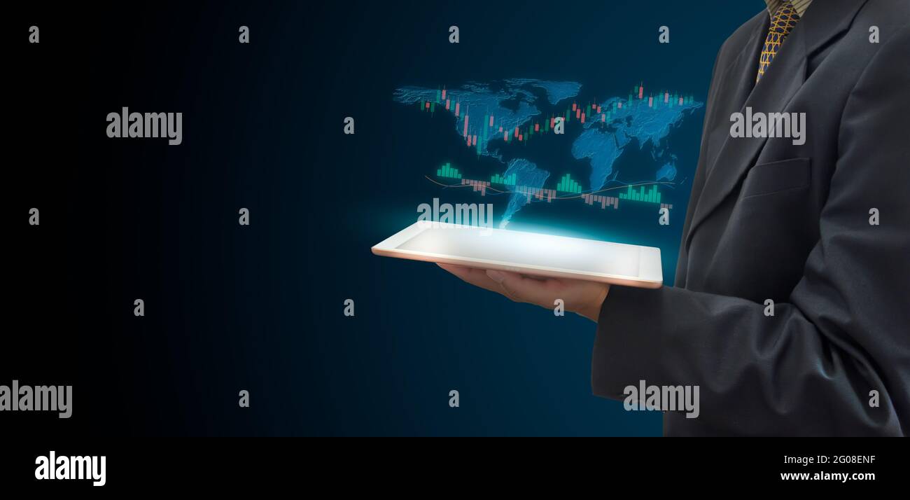Stock market trading concept with a digital tablet  businessmen holding hand on virtual screen. Business finance and graph with world map on dark back Stock Photo