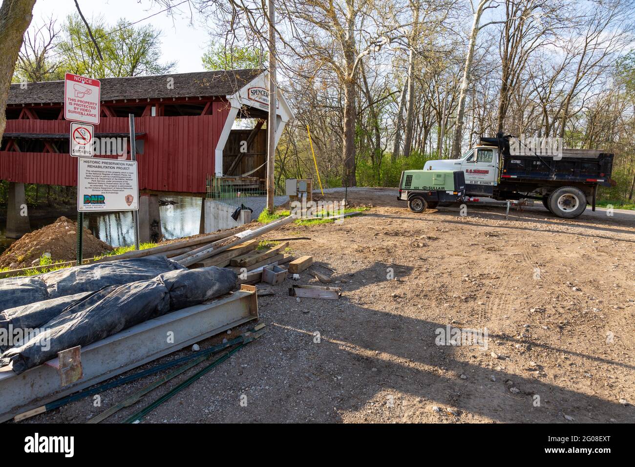 A dump truck and generator sit near the Spencerville Covered Bridge, closed for repairs, in Spencerville, Indiana, USA. Stock Photo