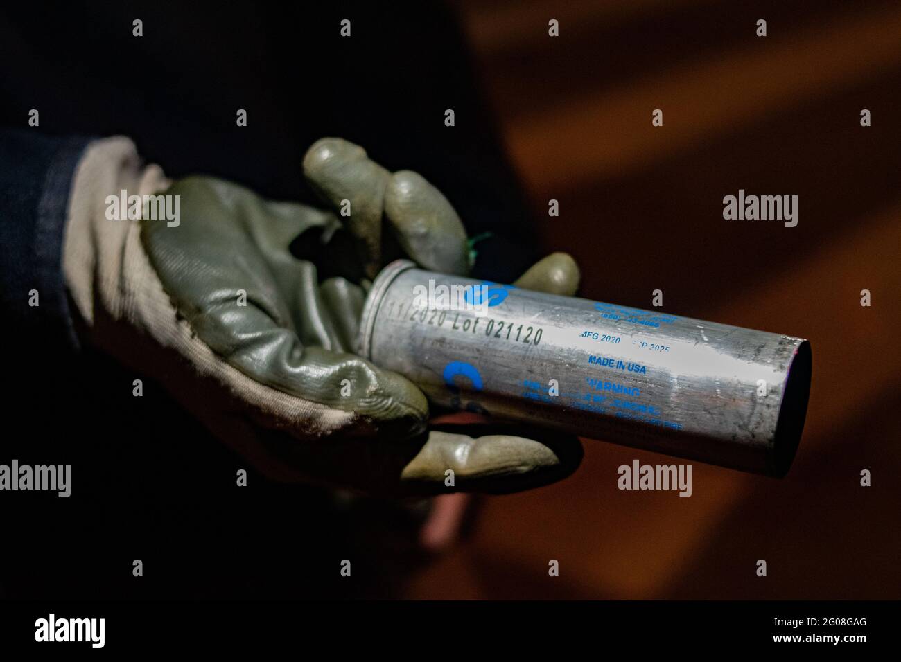 Medellin, Colombia on May 31, 2021. A demonstrator holds a canister of CS Tear gas made in the United States of America as a group of hooded demonstrators clashes with Colombia's riot police (ESMAD) in Medellin, Colombia during the on going anti government protests against Presiden Ivan Duque's tax and health reform and police brutality and unrest that leaves at least 70 dead during the past month, in Medellin, Colombia on May 31, 2021. Stock Photo