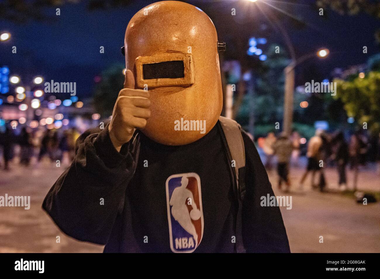 Medellin, Colombia on May 31, 2021. A demonstrator poses for a photo while using a welding mask to protect his identity as a group of hooded demonstrators clashes with Colombia's riot police (ESMAD) in Medellin, Colombia during the on going anti government protests against Presiden Ivan Duque's tax and health reform and police brutality and unrest that leaves at least 70 dead during the past month, in Medellin, Colombia on May 31, 2021. Stock Photo