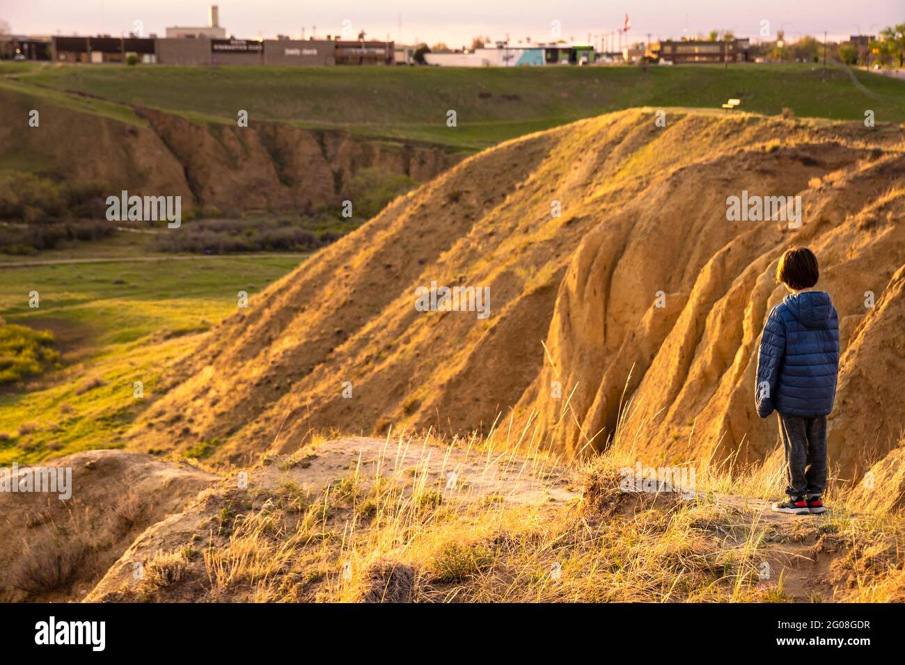 Medicine Hat Alberta Canada, May 14 2021: A young boy watches a sunset over Seven Persons Coulee while on vacation in a Canadian City. Stock Photo