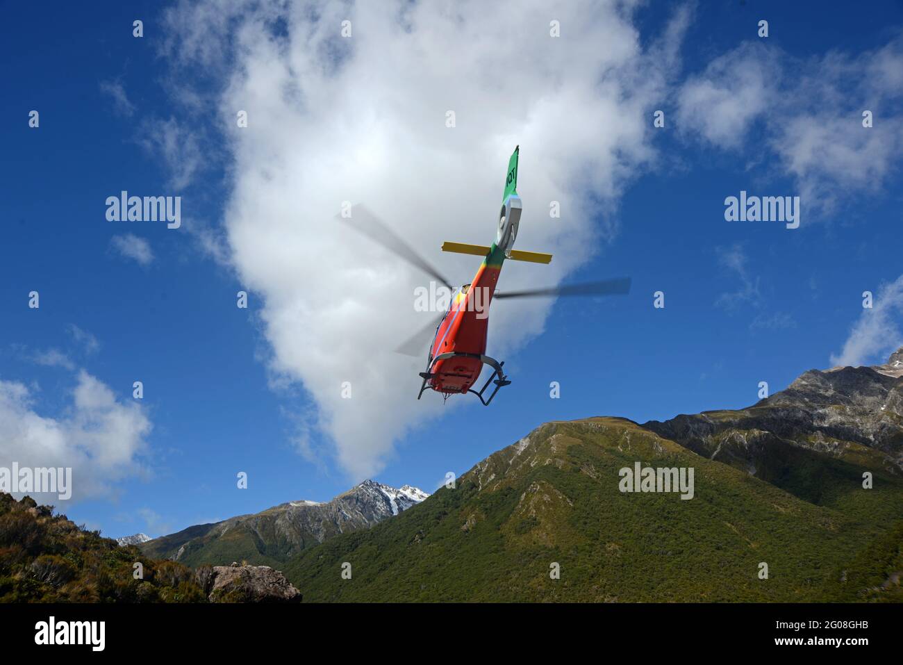ARTHURS PASS, NEW ZEALAND, 2021-01-29: A brightly painted helicopter takes off from a car park in Arthur's Pass National Park, New Zealand Stock Photo