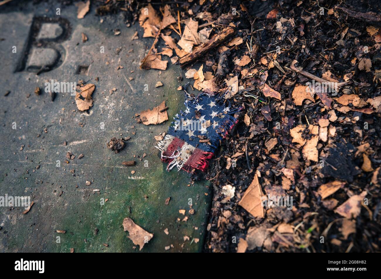 A torn fragment of an American flag on a gravestone Stock Photo