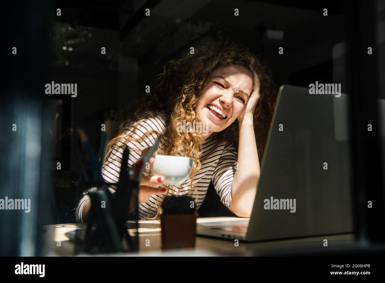Caucasian woman making video call with laptop computer at home in early morning Stock Photo