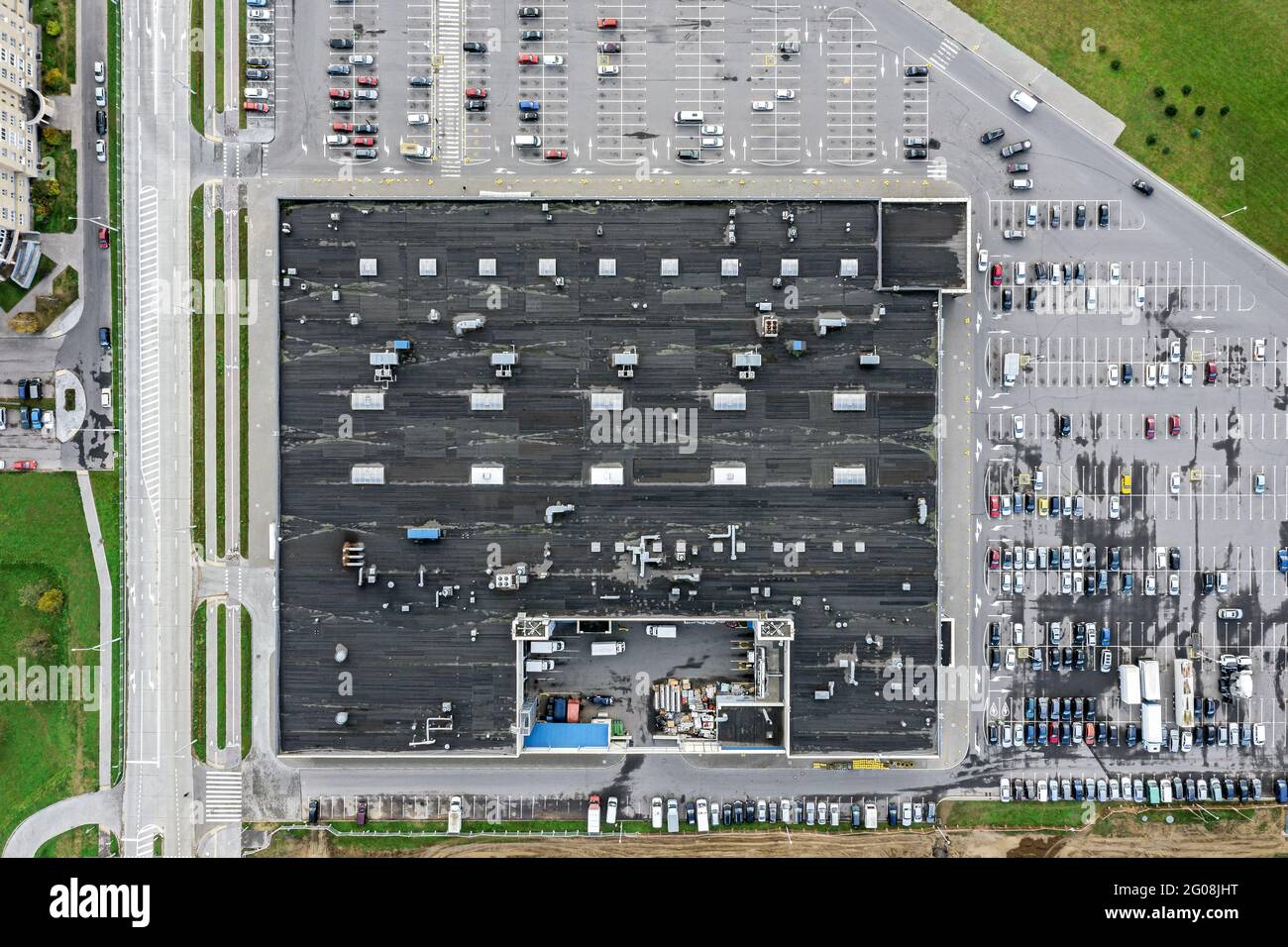 parking lot with parked cars near big city supermarket. aerial top