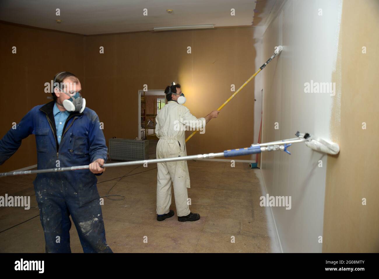 a tradesman using airless spray equipment to paint a primer coat on the
