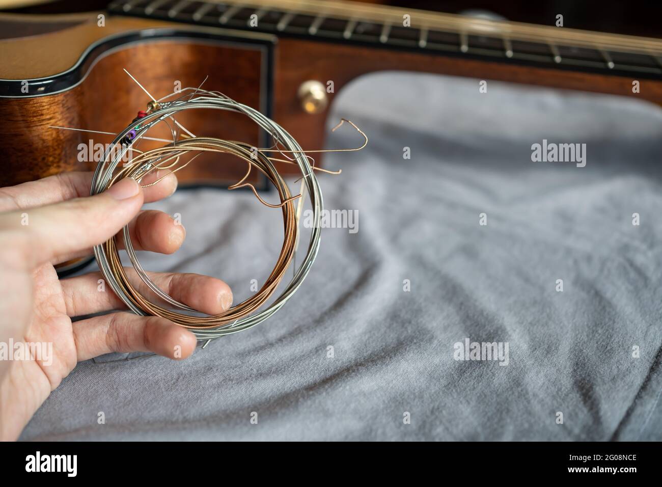 hand holding old steel guitar strings Stock Photo