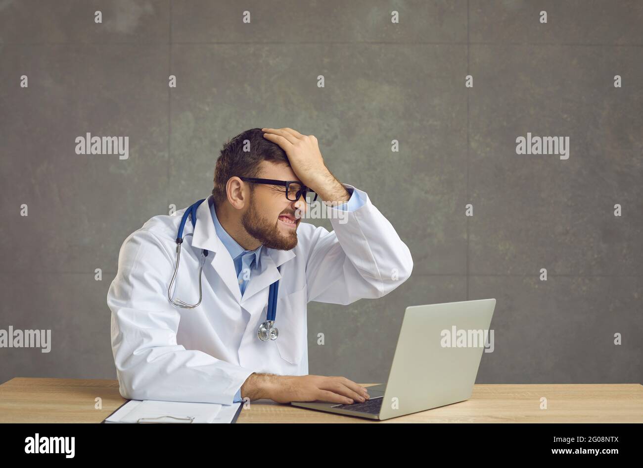 Male doctor forgot something and slapping forehead with palm and closing eyes. Stock Photo