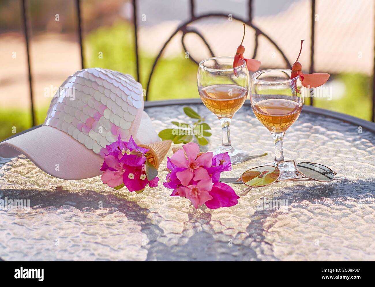 Summer homemade cocktails on bright green background with pink flowers of bougainvillea. Bright women cap. Summer starts creative concept. High quality photo Stock Photo