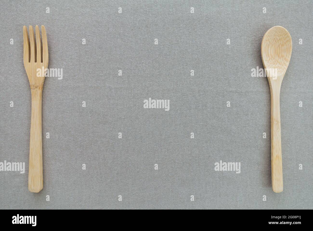 Wooden utensils include spoon and fork with copy space in the middle