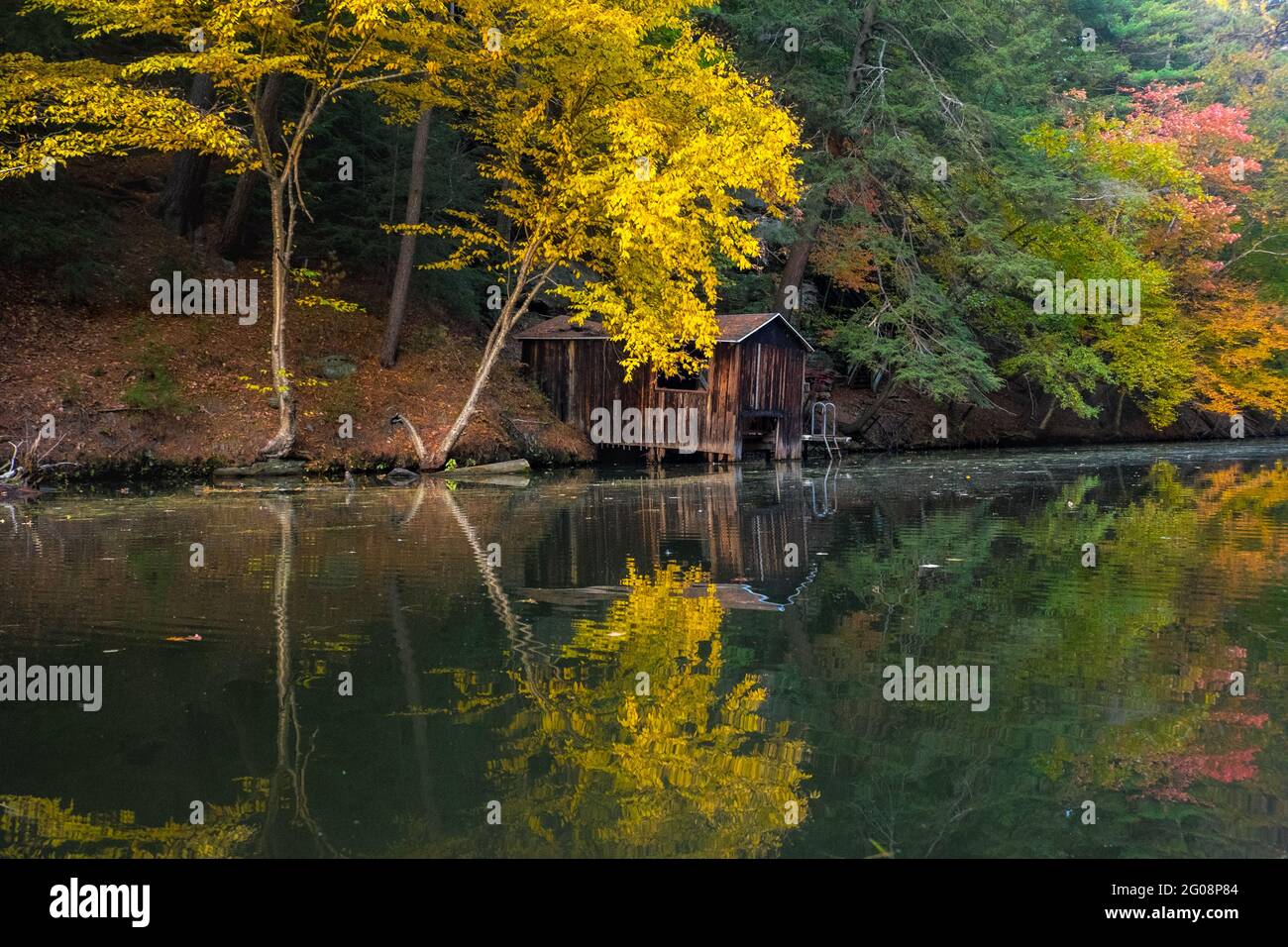 Boathouse and yellow leaves reflected in Mirror Lake, Wisconsin, USA Stock Photo